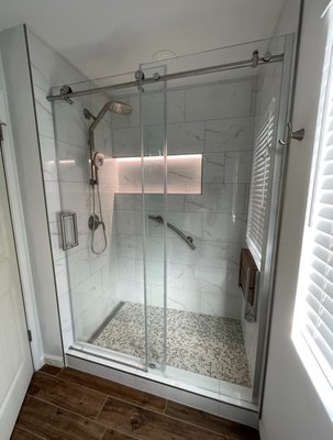 Sun City Bathroom Update - The client wanted a fresh update to their bathrooms. They had a standard tub and plastic surround which we ripped out and replaced with tile and added a custom lighted niche for elegance. Grab bars and a custom drop down bench added for safety and comfort.