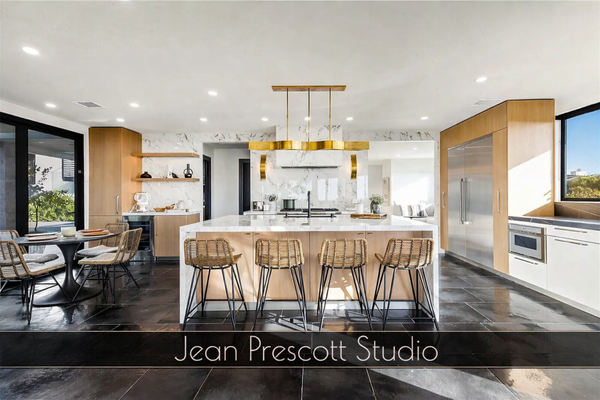 Corona Del Mar Coastal Residence Full Remodel & ADU Over-Garage Suite - This Corona Del Mar coastal residence began as a dated, compartmentalized 4,000 square-foot home that no longer matched the way the owners lived, entertained, or worked. They loved the neighborhood and the proximity to Newport Beach, but the layout felt dark and inefficient and offered no flexible space for guests, extended family, or potential rental income. Jean Prescott Studio was brought in to rethink the property from the ground up: modernizing the main home, adding a new accessory dwelling unit (ADU) above the existing garage, and managing all architectural plans, structural and MEP engineering, and permitting from start to finish.

From the first consultation, the owners described a light-filled, modern coastal home with strong indoor–outdoor connections and a relaxed but refined aesthetic. They wanted an open social core, a quiet primary retreat, and a self-contained ADU that could work as a guest suite or future rental. Because we specialize in remodels and ADUs in Corona Del Mar and Newport Beach, we quickly identified key zoning, setback, height, and parking factors that shaped what was possible both in the main residence and over the garage.

We carefully documented the existing structure and coordinated closely with our structural engineers to see where we could open the plan while maintaining safety and code compliance. The new layout removes unnecessary interior walls, introduces larger openings between living, dining, and kitchen, and adds strategic beams and posts so the home feels open and airy without sacrificing structural integrity. In parallel, we designed a complete ADU above the garage with its own private entrance, efficient kitchenette, full bathroom, and comfortable living and sleeping areas in a compact footprint.
Jean Prescott Studio handled the full permit set in-house: architectural drawings, structural calculations, and MEP (mechanical, electrical, plumbing) plans. For both the main home and the ADU, we prepared detailed floor plans, elevations, sections, roof and ceiling plans, lighting and electrical layouts, and interior details. Our structural team developed foundation and framing plans and lateral bracing details suited to local seismic requirements. MEP design covered HVAC sizing and layout, electrical panel capacity and circuits, lighting design, and plumbing routes serving new kitchens and baths. This integrated approach allowed clashes to be resolved on paper before construction began.

Permitting in coastal communities like Corona Del Mar can be complex, so we managed the entire process on behalf of the owners. We assembled complete submittal packages, coordinated energy compliance documentation, responded to plan-check comments, and revised drawings as needed to secure approvals. Our familiarity with ADU and coastal-area requirements helped streamline reviews and reduce delays.

The design language of the finished home is clean, modern coastal. In the main residence, larger openings connect to the yard, new windows pull in natural light, and finishes balance durability with a calm, neutral palette. The kitchen was completely reimagined with an island-focused layout, efficient appliances, and ample storage. Bathrooms now feature walk-in showers, modern fixtures, and materials that reference the coastal setting without feeling themed. The ADU follows the same level of detail on a smaller scale, using bright finishes, compact fixtures, smart storage, and carefully placed windows to make the space feel generous and independent.

Throughout construction, we remained involved to answer questions, review shop drawings, and visit the site so the built work aligned with the intent of the plans. That collaboration between our architectural team, our engineers, and the contractor helped maintain quality and minimize changes in the field.
The result is a fully transformed 4,000 square-foot Corona Del Mar home that lives like a new custom residence with a highly functional ADU above the garage. The owners gained open, connected living spaces, updated private areas, stronger indoor–outdoor flow, and a flexible secondary unit that can serve as guest quarters, home office, or income-producing rental. For homeowners in Corona Del Mar, Newport Beach, and the greater Orange County area, this project shows what is possible when architectural design, structural and MEP engineering, and permitting are all coordinated through one integrated studio.