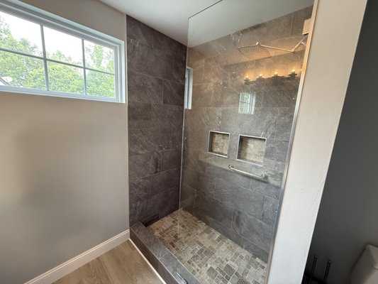Bathroom remodel - This bathroom remodel transformed an outdated tub-shower combo into a modern, walk-in tiled shower. We installed large-format wall tiles, custom niches for storage, and a stone-tiled shower base. The result is a clean, functional, and stylish upgrade that better matches the overall design of the home. Bathroom remodel - This bathroom remodel transformed an outdated tub-shower combo into a modern, walk-in tiled shower. We installed large-format wall tiles, custom niches for storage, and a stone-tiled shower base. The result is a clean, functional, and stylish upgrade that better matches the overall design of the home.