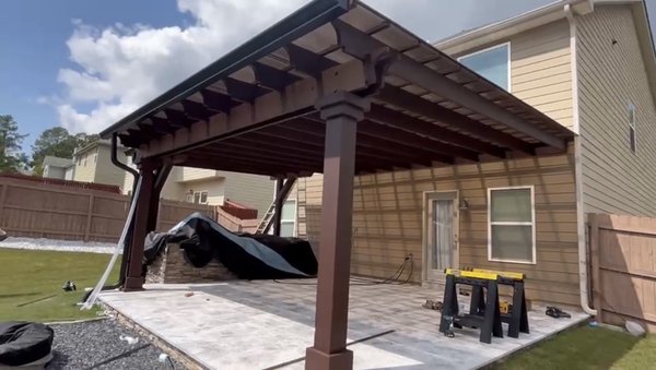 Pergola - This custom-built 26’ x 20’ modern rustic pergola by Spar Gc is the perfect blend of style, durability, and functionality. Designed with robust 8x8 posts made from pressure-treated wood, stained in a rich dark walnut finish, it provides a sturdy foundation and a timeless aesthetic. The dark walnut stain not only enhances the natural beauty of the wood but also offers excellent weather resistance and UV protection, ensuring the pergola remains visually appealing over time.
The structure is featuring the Apollo system twin polycarbonate sheet roof from cover your pergola, known for its impact resistance, UV filtering, and ability to withstand harsh weather, allowing for year-round enjoyment. The open lattice design allows natural light to filter through, while the roof’s UV protection keeps the space comfortable and shielded from direct sunlight. The gutter system is thoughtfully integrated with sleek, dark downspouts that blend seamlessly with the pergola, efficiently channeling rainwater away to keep the area dry and protected.
This pergola also features a beautifully crafted grill area with a stone veneer finish, creating a dedicated, stylish outdoor cooking space that complements the overall design. The result is a versatile and inviting outdoor space, ideal for gatherings, relaxation, and outdoor dining, backed by 5-year installation warranty for added peace of mind.
Click the link below to view 3-d model of pergola.
https://collaborate.shapr3d.com/v/RjCkT2R5DDNU-lPgXG62D Pergola - This custom-built 26’ x 20’ modern rustic pergola by Spar Gc is the perfect blend of style, durability, and functionality. Designed with robust 8x8 posts made from pressure-treated wood, stained in a rich dark walnut finish, it provides a sturdy foundation and a timeless aesthetic. The dark walnut stain not only enhances the natural beauty of the wood but also offers excellent weather resistance and UV protection, ensuring the pergola remains visually appealing over time.
The structure is featuring the Apollo system twin polycarbonate sheet roof from cover your pergola, known for its impact resistance, UV filtering, and ability to withstand harsh weather, allowing for year-round enjoyment. The open lattice design allows natural light to filter through, while the roof’s UV protection keeps the space comfortable and shielded from direct sunlight. The gutter system is thoughtfully integrated with sleek, dark downspouts that blend seamlessly with the pergola, efficiently channeling rainwater away to keep the area dry and protected.
This pergola also features a beautifully crafted grill area with a stone veneer finish, creating a dedicated, stylish outdoor cooking space that complements the overall design. The result is a versatile and inviting outdoor space, ideal for gatherings, relaxation, and outdoor dining, backed by 5-year installation warranty for added peace of mind.
Click the link below to view 3-d model of pergola.
https://collaborate.shapr3d.com/v/RjCkT2R5DDNU-lPgXG62D