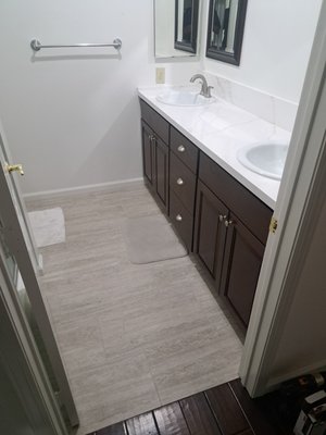 Bathroom Remodel - This Bathroom was left unfinished by a previous contractor, we installed new tile flooring, new baseboards, a new Quartz countertop, new faucets and sinks.