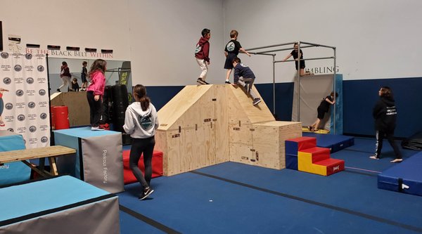 Parkour - Students will learn how to negotiate their way on, around and off of our in-house Parkour picnic table, rail system and specialty Parkour equipment to increase the students' efficiency and skill for outdoor play, all while practicing in a safe and padded environment.
