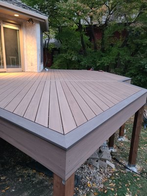 Apple Valley Angular Deck - This deck was built to take place of an old smaller deck that previously existed. The customer wanted to have a new useable space that allowed for a full dining area and also this deck functions as access to the back yard, and garage back door.
The home this deck is built on is very angular and our design takes off square from the largest wall with decking, while the perimeter follows the house walls with its varying 45 degree angles. This created a very nice footprint that matches the house and also gave opportunity for our decking layout to engage areas of the deck at 45 degrees which is very aesthetically pleasing.
The black aluminum railing has LED wired down lights, for a great night ambiance. Also these railing posts were positioned to share the angle vs. being square with one edge which was an option created by this design.
The frame work is built of KDAT brown treated lumber which structurally is far superior to green treated lumber with its lighter weight, lower potential deflection, better initial rigidity, and its color looking of a more refined finished wood. This framing material is something we use on every build of ours. Apple Valley Angular Deck - This deck was built to take place of an old smaller deck that previously existed. The customer wanted to have a new useable space that allowed for a full dining area and also this deck functions as access to the back yard, and garage back door.
The home this deck is built on is very angular and our design takes off square from the largest wall with decking, while the perimeter follows the house walls with its varying 45 degree angles. This created a very nice footprint that matches the house and also gave opportunity for our decking layout to engage areas of the deck at 45 degrees which is very aesthetically pleasing.
The black aluminum railing has LED wired down lights, for a great night ambiance. Also these railing posts were positioned to share the angle vs. being square with one edge which was an option created by this design.
The frame work is built of KDAT brown treated lumber which structurally is far superior to green treated lumber with its lighter weight, lower potential deflection, better initial rigidity, and its color looking of a more refined finished wood. This framing material is something we use on every build of ours.