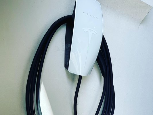 EV charger installations. - Two different EVs getting their charger installed. EV charger installations. - Two different EVs getting their charger installed.