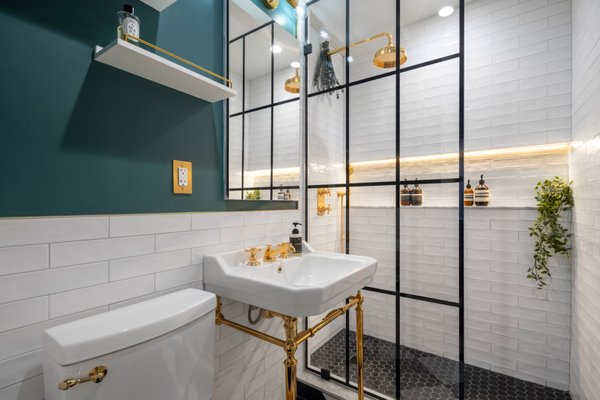 Elegant Bathroom Renovation in Manhattan - This Manhattan bathroom by NYKB blends classic and modern design with a bold yet refined approach. Crisp white subway tiles create a clean base, complemented by rich teal walls that add depth and character.
Brushed brass fixtures throughout bring warmth and a luxurious feel, while the black-framed glass shower adds a sleek, modern contrast. A geometric black and white floor ties the space together, adding a timeless touch.
The result is a compact bathroom that feels elevated, stylish, and thoughtfully designed. Elegant Bathroom Renovation in Manhattan - This Manhattan bathroom by NYKB blends classic and modern design with a bold yet refined approach. Crisp white subway tiles create a clean base, complemented by rich teal walls that add depth and character.
Brushed brass fixtures throughout bring warmth and a luxurious feel, while the black-framed glass shower adds a sleek, modern contrast. A geometric black and white floor ties the space together, adding a timeless touch.
The result is a compact bathroom that feels elevated, stylish, and thoughtfully designed.