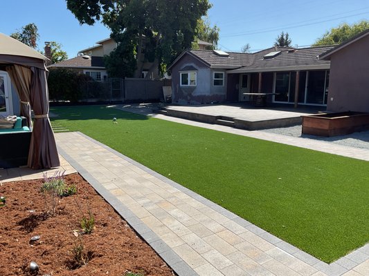Backyard Transformation with Paver Patio - This backyard remodel involves the demolition of the pool area to create a more open and functional space. The area was redesigned with artificial turf, patio and walkway pavers, outdoor steps, custom planters, and outdoor lighting. Completed in San Jose, CA (95128). Backyard Transformation with Paver Patio - This backyard remodel involves the demolition of the pool area to create a more open and functional space. The area was redesigned with artificial turf, patio and walkway pavers, outdoor steps, custom planters, and outdoor lighting. Completed in San Jose, CA (95128).