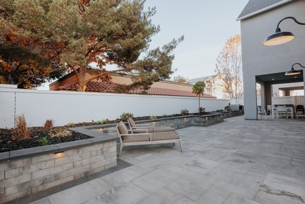 Elegant Small Backyard Oasis Transformation in Rancharrah - Project Overview:
Our recent project transformed a compact backyard space into an elegant oasis, combining functionality with modern design elements to create a serene outdoor retreat. Despite the size constraints, our goal was to maximize the area's potential and deliver a stunning, low-maintenance outdoor living space.
Features Implemented:
Raised Planter with Integrated Lighting: At the heart of this transformation is a beautifully crafted raised planter, which not only adds dimension to the space but also serves as a focal point. Integrated lighting illuminates the planter, highlighting the beauty of the plants within and providing ambient lighting after sunset.
Extensive Use of Pavers: To enhance the functionality and aesthetic appeal of the backyard, we installed a variety of pavers throughout the space. The pavers create a cohesive look, define distinct areas within the small yard, and are chosen for their durability and ease of maintenance.
High-Quality Artificial Turf: Recognizing the desire for a green space without the upkeep, we laid down premium artificial turf. This choice ensures a year-round lush appearance, reduces maintenance, and provides a durable, pet-friendly area for enjoyment.
Selection of Plants: To infuse life and color into the space, we strategically selected and placed a variety of plants around the perimeter and within the raised planter. The selection was tailored to the client's preferences and the local climate, ensuring that the space remains vibrant and inviting with minimal care.
Conclusion:
This project showcases our expertise in transforming limited spaces into beautiful, functional outdoor areas. Our commitment to quality materials, thoughtful design, and client collaboration has resulted in a backyard oasis that can be enjoyed for years to come with minimal upkeep.
Contact Us:
Interested in converting your small yard into a functional paradise? Contact us to learn more about our services and how we can help bring your vision for a tranquil outdoor space to life. Elegant Small Backyard Oasis Transformation in Rancharrah - Project Overview:
Our recent project transformed a compact backyard space into an elegant oasis, combining functionality with modern design elements to create a serene outdoor retreat. Despite the size constraints, our goal was to maximize the area's potential and deliver a stunning, low-maintenance outdoor living space.
Features Implemented:
Raised Planter with Integrated Lighting: At the heart of this transformation is a beautifully crafted raised planter, which not only adds dimension to the space but also serves as a focal point. Integrated lighting illuminates the planter, highlighting the beauty of the plants within and providing ambient lighting after sunset.
Extensive Use of Pavers: To enhance the functionality and aesthetic appeal of the backyard, we installed a variety of pavers throughout the space. The pavers create a cohesive look, define distinct areas within the small yard, and are chosen for their durability and ease of maintenance.
High-Quality Artificial Turf: Recognizing the desire for a green space without the upkeep, we laid down premium artificial turf. This choice ensures a year-round lush appearance, reduces maintenance, and provides a durable, pet-friendly area for enjoyment.
Selection of Plants: To infuse life and color into the space, we strategically selected and placed a variety of plants around the perimeter and within the raised planter. The selection was tailored to the client's preferences and the local climate, ensuring that the space remains vibrant and inviting with minimal care.
Conclusion:
This project showcases our expertise in transforming limited spaces into beautiful, functional outdoor areas. Our commitment to quality materials, thoughtful design, and client collaboration has resulted in a backyard oasis that can be enjoyed for years to come with minimal upkeep.
Contact Us:
Interested in converting your small yard into a functional paradise? Contact us to learn more about our services and how we can help bring your vision for a tranquil outdoor space to life.