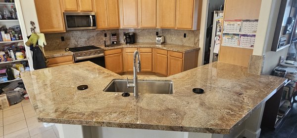 Kitchen Remodel All granite counter with backsplash - This remodel involved removing old materials and lowering the raised bar top to create a level island. We also removed the existing top-mount stove, and adjusted the cabinetry to accommodate a slide-in stove/oven. Finally, we fabricated and installed the granite countertops and backsplash.
