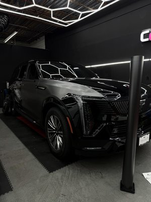 Color Change Wrap - 2026 Cadillac Escalade IQL 1000e came in for a transformation. From factory black to Satin Dark Grey! Protected with a 7 year ceramic coating. Completed the look by tinting the 2 front doors and full front windshield
