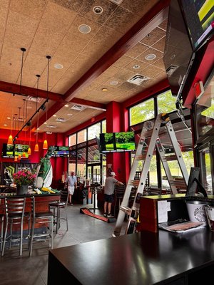 8 TV Installations for Atlanta Sports Bar — 4-Screen Video Wall, 2x 86" Displays & 3 Large TVs Mounted at 17ft for Maximum Visibility - We were hired by a popular Atlanta sports bar to upgrade their entire entertainment setup and create a visually impressive multi-screen experience for their guests. The scope included mounting two 86-inch TVs, three 65-inch screens, and building a quad TV wall using four synchronized displays — all installed at heights of up to 16–17 feet to ensure visibility across the entire venue.

Our team worked within an active bar environment and completed the entire project in just two days, minimizing disruption to the business and ensuring every screen was safely installed, aligned, and tested for flawless playback.

🔧 What We Did:
Mounted 2x 86” TVs on opposite sides of the venue for maximum visibility

Installed 3x 65” TVs in strategic viewing locations

Built a 4-screen video wall (2x2 configuration) with frame-level precision

Secured all mounts at high elevation (~17 feet) using commercial-grade brackets

Routed all cabling through ceilings and walls for a clean, wire-free look

Calibrated screen angles, synced sources, and tested all connections

Completed the full project in just 48 hours

✅ Result:
The final installation completely transformed the bar’s atmosphere. Whether guests are seated at the bar, in dining booths, or near the patio — there’s always a perfect view. The screens are flush-mounted, evenly spaced, and deliver a premium experience ideal for sports, events, or ambient content.

This commercial TV installation project sets the bar high — literally — with professional, fast, and visually stunning results.