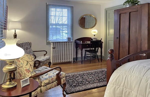 Room Five - "Garden Room" - This two-windowed, roomy suite, with a garden decor, has a lovely, peaceful aura. The comfortable queen bed was originally made in West Virginia. Additionally, there is a vintage armoire, an antique writing desk and a comfortable sitting area. The ensuite bathroom has been recently refreshed in appearance. It has a tub-shower combination, and features a custom pipe towel rack and a large window. Room Five - "Garden Room" - This two-windowed, roomy suite, with a garden decor, has a lovely, peaceful aura. The comfortable queen bed was originally made in West Virginia. Additionally, there is a vintage armoire, an antique writing desk and a comfortable sitting area. The ensuite bathroom has been recently refreshed in appearance. It has a tub-shower combination, and features a custom pipe towel rack and a large window.
