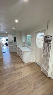 Beach Cottage Remodel - This was a remodel of a rental beach cottage. The small two-bedroom unit had dark paneling, old carpeting, poor lighting, and a dated kitchen with limited storage and countertop space. We proposed and were hired to perform a complete update of the unit that included moving and expanding the width of the front door and the opening between the kitchen and living room (including removing a load-bearing post). We upgraded the plumbing, electrical outlets, and added ceiling lights. New vinyl windows were installed. A new kitchen with quartz countertops, and Luxury Vinyl Tile (LVT), floor coverings were installed throughout. Much work and effort were put into sanding and painting the dark wall paneling with light-color paint. A tankless water heater was installed as were LED ceiling lights and tongue and groove paneling on the porch ceiling. The end result was a completely transformed space that went from being dark and stuffy to light, spacious, and inviting. A truly joyful space for the lucky new tenants! Beach Cottage Remodel - This was a remodel of a rental beach cottage. The small two-bedroom unit had dark paneling, old carpeting, poor lighting, and a dated kitchen with limited storage and countertop space. We proposed and were hired to perform a complete update of the unit that included moving and expanding the width of the front door and the opening between the kitchen and living room (including removing a load-bearing post). We upgraded the plumbing, electrical outlets, and added ceiling lights. New vinyl windows were installed. A new kitchen with quartz countertops, and Luxury Vinyl Tile (LVT), floor coverings were installed throughout. Much work and effort were put into sanding and painting the dark wall paneling with light-color paint. A tankless water heater was installed as were LED ceiling lights and tongue and groove paneling on the porch ceiling. The end result was a completely transformed space that went from being dark and stuffy to light, spacious, and inviting. A truly joyful space for the lucky new tenants!