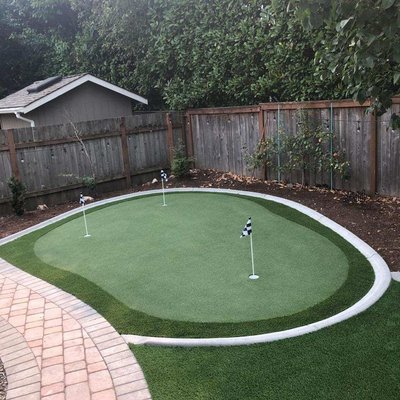 Putting Greens - Cement edging offers a perfect border for synthetic Turf and putting greens.  We can put the curbing in and the turf installers can cut the yard right into whatever shape you desire.