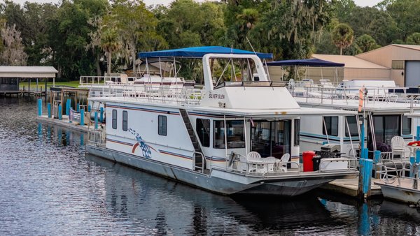 60’ 10 Sleeper Executive Silver Glen - The main salon features the helm, large living room with flat screen TV, dining table with bench seating and 2 chairs, plus well equipped galley. The boat has four private staterooms, a spacious master stateroom with queen size bed, two lower staterooms with queen size beds and one mid-stateroom with full size bed. Add the full size futon in the main salon and this boat comfortably sleeps ten people. The boat has one full bath with shower and one half bath. This boat is equipped with central air and heat. The large front deck features a ceiling fan, propane gas grill, ice chest, table and four chairs. The large back deck has plenty of space for stowing kayaks and water toys. Stairs are located on the front and back decks for easy access to the top deck. There is a flybridge on the top deck so the boat can be driven from inside the boat or from up top. The top deck also has loungers for sunbathing. A canopy top provides partial coverage for those who prefer shade. As of 8/17/2021, this boat no longer includes a water slide.
