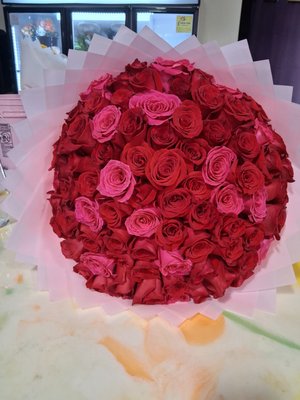 100 Rose Count - A stunning arrangement featuring 100 premium, long-stem roses, meticulously selected for their vibrant color, lush petals, and exceptional freshness. This grand bouquet is designed to make an unforgettable statement—perfect for milestone celebrations, romantic gestures, or luxurious events. Each rose is carefully arranged to showcase its natural beauty, creating a breathtaking display of elegance and sophistication. 100 Rose Count - A stunning arrangement featuring 100 premium, long-stem roses, meticulously selected for their vibrant color, lush petals, and exceptional freshness. This grand bouquet is designed to make an unforgettable statement—perfect for milestone celebrations, romantic gestures, or luxurious events. Each rose is carefully arranged to showcase its natural beauty, creating a breathtaking display of elegance and sophistication.