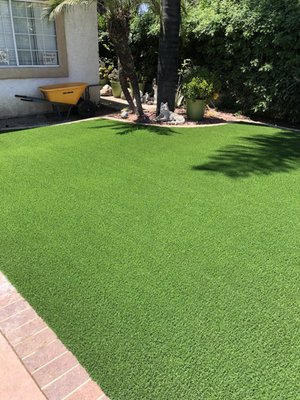 Artificial Turf - We installed artificial turf to bring vibrant green to the space that stays perfect all year round. For this project, we brought in a premium, realistic turf variety designed to handle heavy foot traffic and pets while providing maximum drainage.
How We Built It:
Complete Ground Prep: We excavated the old sod and dirt, then brought in a specialized crushed stone base and compacted it heavily. This creates a rock-solid, smooth foundation that eliminates any dipping or uneven spots.
Seamless Cutting & Securing: Our crew meticulously cut the turf rolls to fit the yard's unique perimeter, hiding the seams perfectly and securing the edges tightly with heavy-duty landscape staples so it never shifts or lifts.
Infill & Fluff Finish: We brushed in high-quality infill sand to weigh down the turf, keeping the blades standing completely upright, and ensure quick water drainage. Artificial Turf - We installed artificial turf to bring vibrant green to the space that stays perfect all year round. For this project, we brought in a premium, realistic turf variety designed to handle heavy foot traffic and pets while providing maximum drainage.
How We Built It:
Complete Ground Prep: We excavated the old sod and dirt, then brought in a specialized crushed stone base and compacted it heavily. This creates a rock-solid, smooth foundation that eliminates any dipping or uneven spots.
Seamless Cutting & Securing: Our crew meticulously cut the turf rolls to fit the yard's unique perimeter, hiding the seams perfectly and securing the edges tightly with heavy-duty landscape staples so it never shifts or lifts.
Infill & Fluff Finish: We brushed in high-quality infill sand to weigh down the turf, keeping the blades standing completely upright, and ensure quick water drainage.