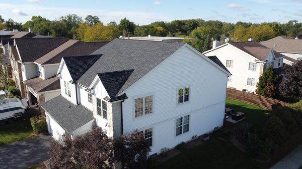 Roof, Siding, and Gutter replacement - Giving this home a brand new look with a Granite Black Dynasty roof, black gutters, white siding, and white board and batten accent siding!