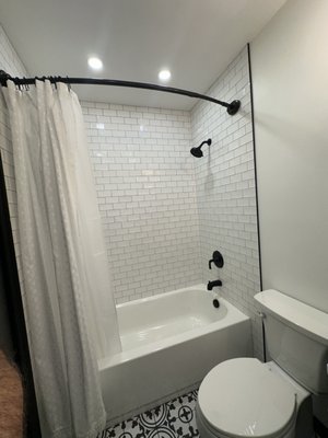Guest Bathroom, Falls Church, VA. - This outdated hall bathroom, featuring a standard-sized tub, required extensive repairs due to water damage. The project included floor repairs, along with necessary electrical and plumbing modifications to ensure a modern, functional space.