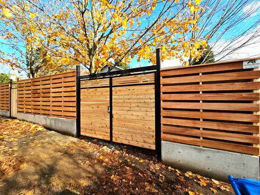 Custom horizontal fence - Our customer had a few ideas in mind and wanted his fence to be a bit different from the basic horizontal fences around his area. He wanted to ensure the gates provided the security he needed for his home so we customized the frames so these could work with the keyless entry pads he wanted to use.