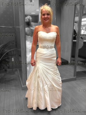 Lace & Satin Wedding Dress - Our lovely customer came in and requested that we add in this beautiful rhinestone belt to her wedding dress. We took-in the sides and added a bustle at the back of her dress. Lace & Satin Wedding Dress - Our lovely customer came in and requested that we add in this beautiful rhinestone belt to her wedding dress. We took-in the sides and added a bustle at the back of her dress.
