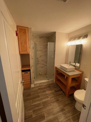 Custom Bathroom Renovation - Complete Bathroom Transformation

This bathroom was ready for a complete transformation. The existing space featured dated finishes and an inefficient layout that limited both functionality and storage.

Koproski & Vaughan redesigned the space to create a more refined and functional bathroom, replacing the existing tub with a fully tiled walk-in tile shower. To maximize storage, we incorporated a custom built-in cabinet with an integrated laundry hamper, designed specifically around the needs of the space.

The vanity was also custom-built in-house to complement the built-in cabinetry, creating a cohesive, tailored look throughout the bathroom. The renovation was completed with wood-grain tile flooring and finishes that bring together the warmth of natural wood with the durability and practicality of tile.

The result is a thoughtfully designed bathroom that combines elevated style, custom craftsmanship, and everyday functionality.