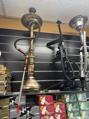 Hookah - Smoke Villa: Your Hookah Headquarters
At Smoke Villa, we celebrate the art and tradition of hookah with a premium selection of pipes, shisha flavors, and accessories. Whether you’re new to hookah or a seasoned enthusiast, our smoke shop is your one-stop destination for everything you need to enjoy a rich, relaxing session—solo or with friends.

What You’ll Find at Smoke Villa
Hookah Pipes for Every Preference:
Choose from compact portable hookahs, classic traditional designs, or stylish modern glass sets. We offer options for all budgets, gathering sizes, and style preferences.
Extensive Shisha Selection:
Indulge in a wide range of premium shisha flavors—fruit, mint, dessert, classic tobacco, and exotic blends—from top brands like Starbuzz, Al Fakher, Fumari, and Khalil Mamoon.
Hookah Charcoal:
From quick-light tablets to natural coconut coals, we carry safe, high-quality charcoal for a smooth, authentic hookah experience.
Bowls, Hoses, and Mouthpieces:
Upgrade or personalize your rig with our assortment of replacement bowls, washable hoses, silicone tips, diffusers, heat management devices, and decorative accessories.
Hookah Maintenance Supplies:
Keep your hookah clean and tasting fresh with brushes, cleaning solutions, and replacement grommets available in-store.
Why Shop Hookah at Smoke Villa?
Expert Advice:
Our team is here to help you select the right hookah and shisha, walk you through setting up your first session, or recommend accessories that elevate your experience.
Authenticity & Quality:
All our hookah products are genuine and quality-checked—ensuring the flavor, performance, and tradition you expect.
All-in-One Convenience:
No more searching—pick up everything you need for your next hookah session in a single stop.
Specials & Rewards:
Earn loyalty points with every purchase and ask about bundle deals on hookahs, shisha, and charcoal.
Smoke Villa: Experience tradition, social connection, and unbeatable selection with every hookah visit.

Stop by or call us today to explore our latest hookah arrivals, new shisha flavors, and accessories, or get help choosing your perfect setup!