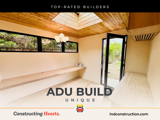 ADU Garage Conversion - Unique - This unique ADU garage door conversion brings warmth and character with natural wood finishes, a skylight that floods the space with light, and custom built-ins that maximize functionality. The modern black-framed windows and door open to a lush yard, creating a perfect indoor-outdoor flow.