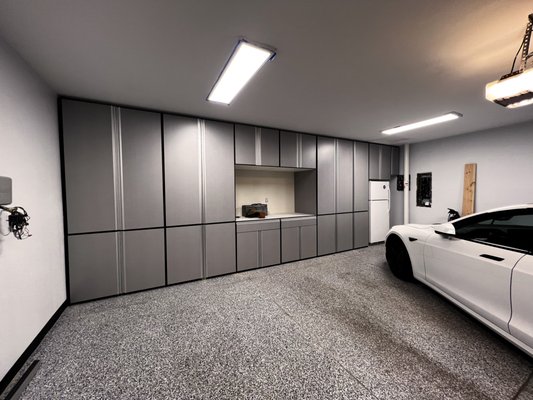 Garage Remodel - This garage needed a little TLC and more functional storage. We replaced the slab cement floor with a more decorative slab cement floor, swapped out the light fixtures, incorporated a Tesla compatible charging station and installed industrial cabinetry with a workspace. Garage Remodel - This garage needed a little TLC and more functional storage. We replaced the slab cement floor with a more decorative slab cement floor, swapped out the light fixtures, incorporated a Tesla compatible charging station and installed industrial cabinetry with a workspace.