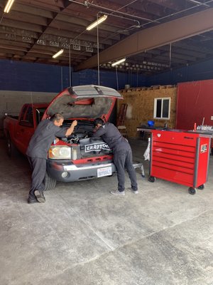 Inspecting a vehicle free of charge. - Two of our best mechanics double checking a diagnosis on a oil leak. Diagnosis are free of charge.