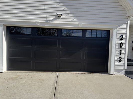 Black Elegance garage door - This stunning black garage door features a sleek matte finish with clean, bold. lines and top-section windows that let in natural light without compromising privacy. Built for both durability and style, it's the perfect upgrade for homeowners looking to add curb appeal with a modern touch. The reinforced steel panels offer strength and insulation, while the minimalist design pairs beautifully with contemporary of classic home.
Whether it's day or night, this door makes a bold statement - Stylish, Secure, And Built to Last. Black Elegance garage door - This stunning black garage door features a sleek matte finish with clean, bold. lines and top-section windows that let in natural light without compromising privacy. Built for both durability and style, it's the perfect upgrade for homeowners looking to add curb appeal with a modern touch. The reinforced steel panels offer strength and insulation, while the minimalist design pairs beautifully with contemporary of classic home.
Whether it's day or night, this door makes a bold statement - Stylish, Secure, And Built to Last.