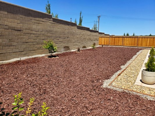 Jim R backyard installation - This project is was completed in two separate phases. First installing rocks, on the side, installing redwood edging, topsoil/compost, planting ground cover and adding Irrigation.
Next it consisted of laying down weed fabric, spreading mulch, installing a water supply, drip line and emitters to the existing plants and finally programming the timer to run automatically. Jim R backyard installation - This project is was completed in two separate phases. First installing rocks, on the side, installing redwood edging, topsoil/compost, planting ground cover and adding Irrigation.
Next it consisted of laying down weed fabric, spreading mulch, installing a water supply, drip line and emitters to the existing plants and finally programming the timer to run automatically.