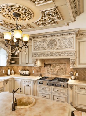 Classic hand carved patina kitchen - Painted over mahogany and complimented with a patina finish, each hand carved element is visually brought to the forefront of the design. Contrasting with the darker color of the central island, these distinctions all aim to improve the overall cohesion within the kitchen itself. Classic hand carved patina kitchen - Painted over mahogany and complimented with a patina finish, each hand carved element is visually brought to the forefront of the design. Contrasting with the darker color of the central island, these distinctions all aim to improve the overall cohesion within the kitchen itself.