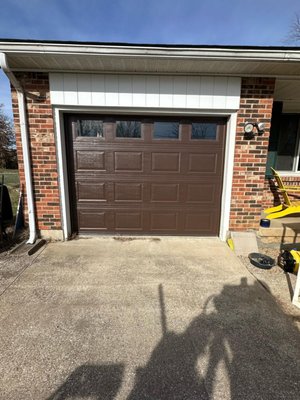 Brown Garage Door Installation – Cincinnati, OH - Residential garage door installation in Cincinnati featuring an insulated brown raised-panel door with upper windows. We completed full removal of the old system, installed new tracks and spring assembly, and ensured smooth, balanced operation. The upgrade improved curb appeal, security, and long-term reliability for the homeowner.