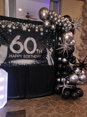 60th Birthday setup! - Sparkle & Shine: 60th Birthday Glam
This dazzling 60th birthday setup was all about the sparkle! We paired a silver and black pipe-and-drape backdrop with a bold 6–7 ft balloon garland, a balloon column topped with a custom glitter-filled Bobo balloon, and glowing 4ft marquee “60” numbers. The client asked for sparkle and pizazz — and we delivered a statement setup worthy of the spotlight!