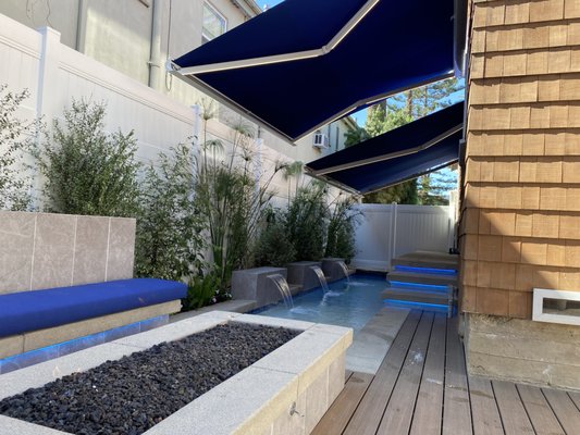 Dual Motorized Retactable Awnings - Design and installation of two motorized retractable awnings to cover the lap pool area, for coverage from sun and privacy for our clients. The full aluminum cassettes Bella Plus and Domina awnings were the perfect combo for this custom installation. The aluminum cassette color was chosen to match the home and Sunbrella Medertrain blue tweed is the perfect accent to the existing patio furniture. Dual Motorized Retactable Awnings - Design and installation of two motorized retractable awnings to cover the lap pool area, for coverage from sun and privacy for our clients. The full aluminum cassettes Bella Plus and Domina awnings were the perfect combo for this custom installation. The aluminum cassette color was chosen to match the home and Sunbrella Medertrain blue tweed is the perfect accent to the existing patio furniture.