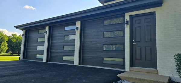 Modern Garage Door Upgrade: Skyline Flush Carbon Oak with Tinted Windows - Before and After: We replaced a damaged garage door with a sleek, modern upgrade. This new Skyline Flush design in Carbon Oak with tinted windows provides an elegant look, enhanced curb appeal, and improved durability.
