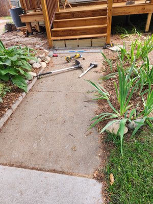 Entry steps code compliant 1011 - The owner built a new entry deck and steps leaving the bottom step out of code specification. We went and removed 10lf. of sidewalk, raising it 3 and a 1/2 in. transitioning down to existing  sidewalk, all in code and specs.