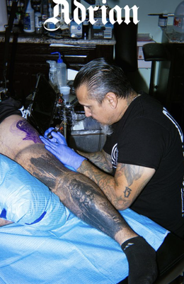 Adrian Lazo - Ten miles east of Rio Grande River is the South Texas tattoo shop, Buena Suerte. Current owner Adrian Lazo has been there for over ten years and tattooing for over 25 years. Specializing in black and grey, but open to many other styles, Adrian has extraordinary attention to detail and shading with his tattoos and freehand drawings on the client’s skin. Since birth, art has been Adrian’s focus and passion, leading him to a career in tattooing beginning at an age of 14. Adrian found means through his makeshift surroundings as a child – building his own machines and burning and mixing his own inks. This may be why he gravitates to black and grey to this day…