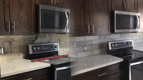 Tiling a backsplash - Our hands-on approach involved the strategic application of thin-set adhesive, securing the tiles with precision. The wall transformed, reflecting our careful measurement and deliberate placement.