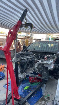Engine Swap 2016 Prius - Our team took on the challenge of performing a complete engine swap for a 2016 Toyota Prius, ensuring that the vehicle could return to peak efficiency and reliability. This intricate project involved carefully removing the existing engine using a hydraulic engine hoist, as shown in the process. Precision and care were paramount to avoid any damage to the surrounding components, including the hybrid system, frame, and electrical connections.

Once the original engine was removed, we meticulously prepared the replacement engine, inspecting it to ensure it was in optimal condition. We also addressed the hybrid system integration and verified that all connectors, sensors, and mounts were perfectly aligned.

The reinstallation process required expertise and attention to detail, given the tight spaces and complex wiring of the Prius. We thoroughly tested the engine post-installation, checking for performance, fuel efficiency, and error codes to guarantee everything was functioning as intended.

This project showcases our team's ability to handle modern hybrid vehicles and perform advanced repairs while maintaining the highest standards of quality and precision. The client now has a fully restored, eco-friendly car ready to hit the road again.