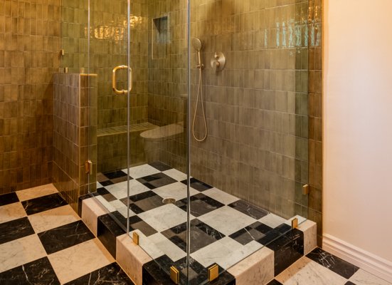Bathroom Remodel San Marino - This custom master bath features elegant black and white marble floors, creating a sophisticated foundation. The walls are adorned with rich green tiles, providing a vibrant contrast, while luxurious golden fixtures add a touch of opulence. The harmonious blend of colors and textures exudes a timeless and lavish ambiance.