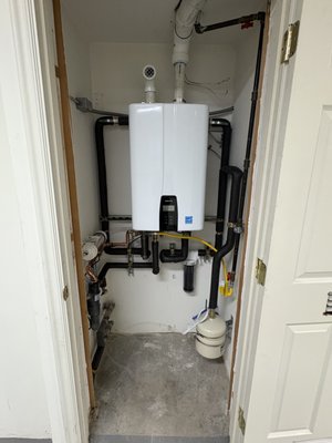 New Navien Tankless sytem - Transform your home’s hot water system with our professional installation of a high-efficiency Navien NPE-240A2 tankless water heater, replacing an outdated 75-gallon power vent tank. Our skilled team executed a seamless water heater service, upgrading your system to deliver endless hot water, enhanced energy efficiency (up to 98% with condensing technology), and a compact, space-saving design. This installation ensures reliable performance, smart technology integration, and eco-friendly operation tailored to modern home needs.Scope of Work:Tank Removal and Replacement: Carefully removed the existing 75-gallon power vent tank, replacing it with the advanced Navien NPE-240A2 tankless water heater for superior efficiency and on-demand hot water.
Gas Line Utilization: Reused the existing 1/2” gas line, ensuring compatibility with the Navien unit for safe and efficient operation, minimizing installation costs.
Water Line Optimization: Rerouted and securely supported water lines around the new tankless unit, ensuring proper flow and system integrity for long-term performance.
Service Valve Installation: Added high-quality service valves to the Navien NPE-240A2, enhancing accessibility for future water heater service and maintenance.
Recirculation Line Reactivation: Reconnected the previously decommissioned recirculation line to the Navien’s dedicated recirc outlet, enabling instant hot water delivery throughout the home for maximum comfort and efficiency.
Condensate and T&P Drainage: Configured the condensate line and temperature/pressure (T&P) relief valve to tie into the existing 2” ABS drain with a trap in the mechanical room, ensuring safe and compliant drainage.
Ventilation System: Reused the existing 3” PVC exhaust line for efficient venting and configured a 2” intake to draw fresh air from the spacious 1000+ sq ft basement, optimizing combustion and safety.
Future-Ready Design: Planned for future intake/exhaust rerouting to accommodate an upcoming basement remodel, ensuring flexibility and adaptability for your evolving home.
Descaling Protection: Installed a descale filter on the cold water supply line to protect the Navien NPE-240A2 from mineral buildup, extending the unit’s lifespan and maintaining peak performance.
Why Choose This Upgrade?
The Navien NPE-240A2 is a state-of-the-art tankless water heater, offering 199,000 BTU output, smart controls, and WiFi compatibility for remote monitoring. This installation not only provides endless hot water but also reduces energy bills by up to 30% compared to traditional tank systems, making it an eco-friendly choice for modern households. Our meticulous water heater service ensures every detail—from gas and water line integration to drainage and ventilation—meets the highest industry standards for safety, efficiency, and durability.Customer Benefits:Energy Efficiency: 98% efficient condensing technology lowers utility costs and environmental impact.
Space-Saving Design: Compact tankless unit frees up valuable basement space.
Endless Hot Water: On-demand system ensures no more cold showers, even during peak usage.
Long-Term Reliability: Descale filter and service valves simplify maintenance, prolonging system life.
Future-Proof Installation: Designed with upcoming basement remodel in mind for seamless integration.
Our team takes pride in delivering top-tier water heater installation and replacement services, ensuring your Navien NPE-240A2 performs flawlessly for years to come. Contact us for expert water heater service that prioritizes quality, efficiency, and customer satisfaction! #TanklessWaterHeater #WaterHeaterService #Navien New Navien Tankless sytem - Transform your home’s hot water system with our professional installation of a high-efficiency Navien NPE-240A2 tankless water heater, replacing an outdated 75-gallon power vent tank. Our skilled team executed a seamless water heater service, upgrading your system to deliver endless hot water, enhanced energy efficiency (up to 98% with condensing technology), and a compact, space-saving design. This installation ensures reliable performance, smart technology integration, and eco-friendly operation tailored to modern home needs.Scope of Work:Tank Removal and Replacement: Carefully removed the existing 75-gallon power vent tank, replacing it with the advanced Navien NPE-240A2 tankless water heater for superior efficiency and on-demand hot water.
Gas Line Utilization: Reused the existing 1/2” gas line, ensuring compatibility with the Navien unit for safe and efficient operation, minimizing installation costs.
Water Line Optimization: Rerouted and securely supported water lines around the new tankless unit, ensuring proper flow and system integrity for long-term performance.
Service Valve Installation: Added high-quality service valves to the Navien NPE-240A2, enhancing accessibility for future water heater service and maintenance.
Recirculation Line Reactivation: Reconnected the previously decommissioned recirculation line to the Navien’s dedicated recirc outlet, enabling instant hot water delivery throughout the home for maximum comfort and efficiency.
Condensate and T&P Drainage: Configured the condensate line and temperature/pressure (T&P) relief valve to tie into the existing 2” ABS drain with a trap in the mechanical room, ensuring safe and compliant drainage.
Ventilation System: Reused the existing 3” PVC exhaust line for efficient venting and configured a 2” intake to draw fresh air from the spacious 1000+ sq ft basement, optimizing combustion and safety.
Future-Ready Design: Planned for future intake/exhaust rerouting to accommodate an upcoming basement remodel, ensuring flexibility and adaptability for your evolving home.
Descaling Protection: Installed a descale filter on the cold water supply line to protect the Navien NPE-240A2 from mineral buildup, extending the unit’s lifespan and maintaining peak performance.
Why Choose This Upgrade?
The Navien NPE-240A2 is a state-of-the-art tankless water heater, offering 199,000 BTU output, smart controls, and WiFi compatibility for remote monitoring. This installation not only provides endless hot water but also reduces energy bills by up to 30% compared to traditional tank systems, making it an eco-friendly choice for modern households. Our meticulous water heater service ensures every detail—from gas and water line integration to drainage and ventilation—meets the highest industry standards for safety, efficiency, and durability.Customer Benefits:Energy Efficiency: 98% efficient condensing technology lowers utility costs and environmental impact.
Space-Saving Design: Compact tankless unit frees up valuable basement space.
Endless Hot Water: On-demand system ensures no more cold showers, even during peak usage.
Long-Term Reliability: Descale filter and service valves simplify maintenance, prolonging system life.
Future-Proof Installation: Designed with upcoming basement remodel in mind for seamless integration.
Our team takes pride in delivering top-tier water heater installation and replacement services, ensuring your Navien NPE-240A2 performs flawlessly for years to come. Contact us for expert water heater service that prioritizes quality, efficiency, and customer satisfaction! #TanklessWaterHeater #WaterHeaterService #Navien