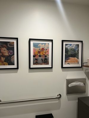 Hanging of arts - Mounted paintings of different sizes in a straight line on drywall.