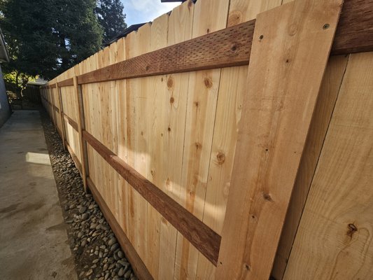 Nail up cedar fence - The traditional wooden fence constructed with the "nail up" method is both straightforward and robust. This type of fence typically comprises adjacent boards that do not overlap. Commonly, it employs either "dog-fence" boards or standard flat top boards. It serves as an excellent means to enhance privacy in your yard, and this design is often a cost-effective choice.