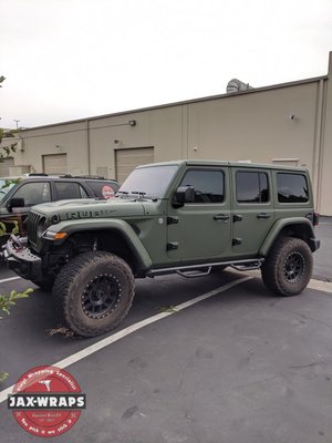 Full Color Change - This Jeep had a great wheel and tire package but after our Military green wrap, it was fully transformed. It looks tactical and war-ready while still wearing some original 'Rubicon" hood decals custom made to match for a factory-looking finish.