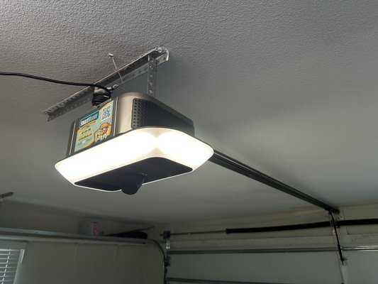 Builder-Grade Opener Upgrade to LiftMaster 87504 - We replaced an outdated ½ HP builder-grade chain-driven LiftMaster opener with a powerful, ultra-quiet ¾ HP belt-driven LiftMaster 87504. This premium model features a built-in camera for real-time video monitoring, along with LED lighting and integrated Wi-Fi for smart control through the myQ app. The result? A smoother, quieter, and more secure garage door system.

Now the homeowner can monitor their garage remotely, open or close the door from anywhere, and enjoy the peace of mind that comes with smart, connected technology.