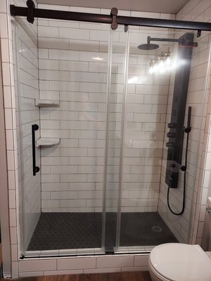 Bathroom Remodel with Custom Vanity - A 1990's bathroom remodel.  Removed bathtub and old vanity.  Converted to new tiled shower with rain shower fixture and 2 corner shelves.  Custom vanity.  Doors are operational deep drawers.