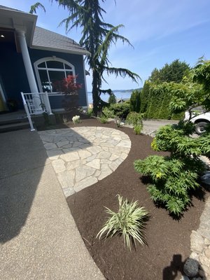 Rock patio - Finished landscape with stone patio, fresh mulch, and a mix of ornamental plants for a clean, coastal look. Rock patio - Finished landscape with stone patio, fresh mulch, and a mix of ornamental plants for a clean, coastal look.