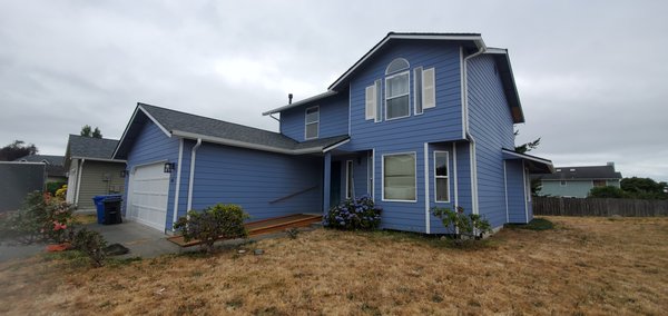 Blue house in Oak harbor - This customer decided to remodel the exterior of his home, They choose TL SOLUTIONS to help on making the house looks amazing. White gutters and downspouts.