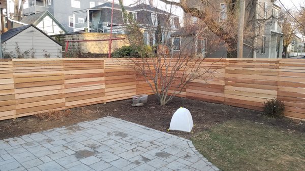 Custom horizontal board fence in Somerville - Custom design horizontal board fence in Somerville with red cedar board.